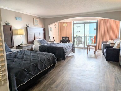 Bedroom with wood-type flooring, a textured ceilin