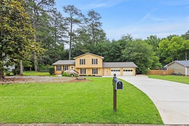 Split level home featuring concrete driveway and an attached garage