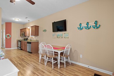 Dining space with ceiling fan and light wood-type 