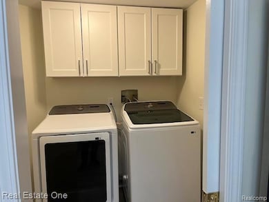 Washroom with cabinet space and washing machine and clothes dryer