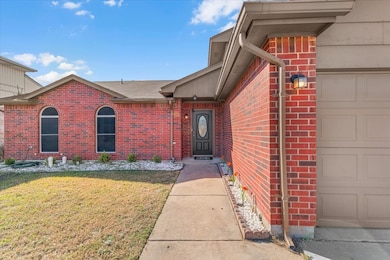 Property entrance featuring brick siding and a lawn