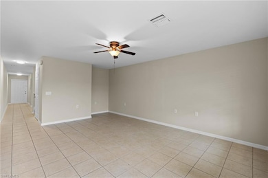 Empty room with light tile patterned flooring and ceiling fan