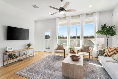 Living area featuring a ceiling fan, wood finishe