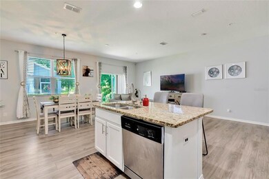 Open kitchen with island overlooking great room and dining area