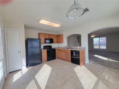 Kitchen with arched walkways, black appliances, li