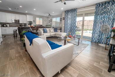 Living area with wood tiled floors, ceiling fan, and recessed lighting