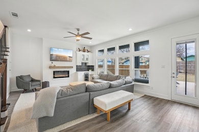 Living room with ceiling fan, & minibar area.