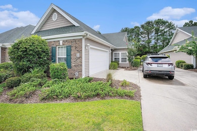View of front facade with driveway, brick siding, a shingled roof, a front lawn, and an attached garage