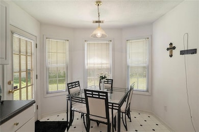 Dining space featuring a textured ceiling and baseboards