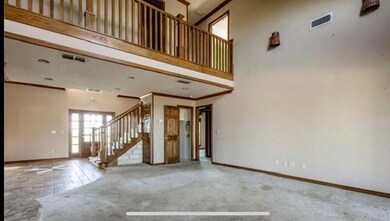 Unfurnished living room featuring a high ceiling and ornamental molding