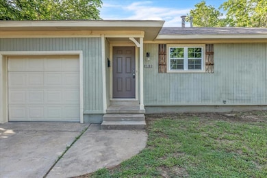 Doorway to property with a garage and driveway