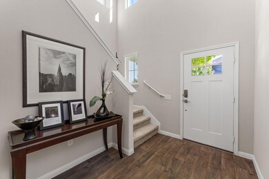 Entrance foyer featuring stairs, dark wood finished floors, and a high ceiling