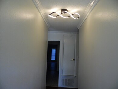 Hall with a textured ceiling and ornamental moldin