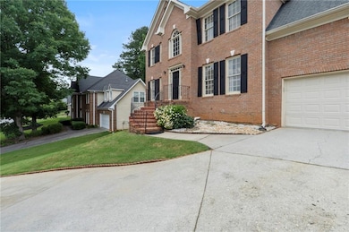 View of front of house with concrete driveway, brick siding, a garage, and a front lawn