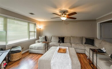 Living room featuring wood-type flooring, crown mo