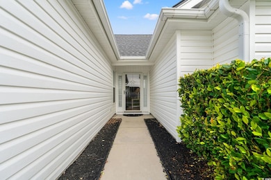 Doorway to property with roof with shingles
