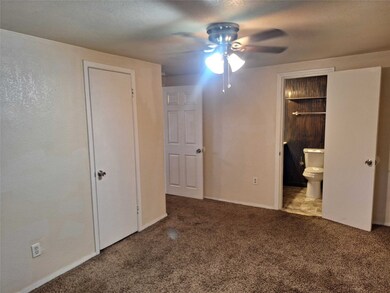 Unfurnished bedroom featuring carpet flooring, a ceiling fan, ensuite bathroom, and a textured ceiling