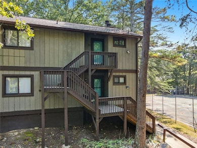 Back of house with stairway, roof with shingles, and a deck