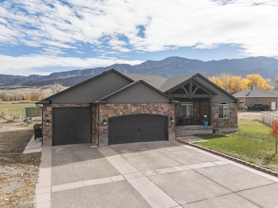 View of front facade with a garage, a mountain view, driveway, and stucco siding