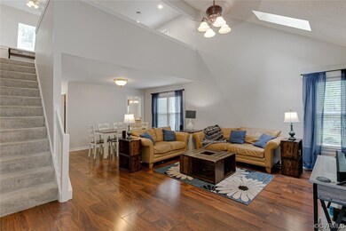 Living room with dark hardwood flooring, a skyligh