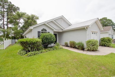View of front of house with a garage, concrete driveway, and metal roof
