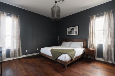 Bedroom featuring multiple windows and wood-type flooring