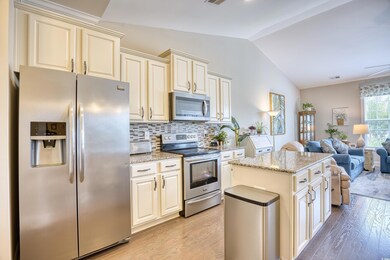 Kitchen featuring backsplash, cream cabinetry, sta
