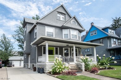 View of front of property with a porch and driveway to detached garage