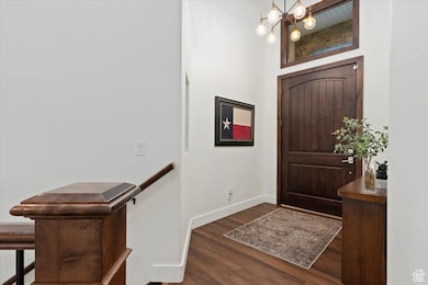 Entrance foyer featuring dark wood finished floors and a chandelier