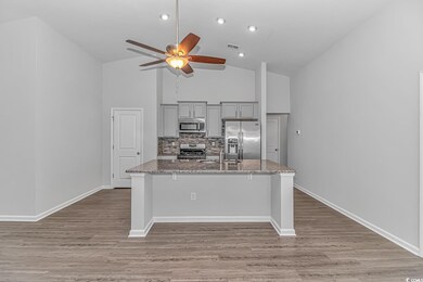 Kitchen featuring a kitchen bar, light stone count