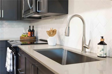 Kitchen featuring sink, stove, and decorative back