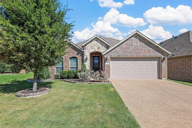 View of front of home with a garage and a front ya