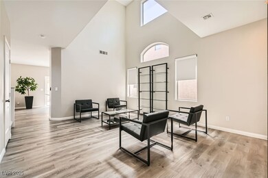 Living area featuring a high ceiling, baseboards,