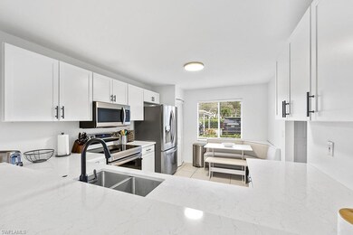 Kitchen featuring white cabinets, light stone coun