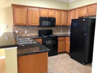 Kitchen featuring black appliances, a sink, tastef
