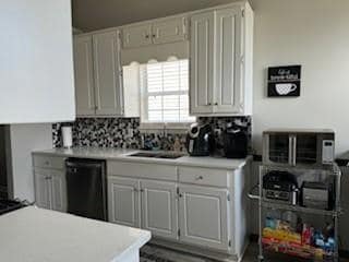 Kitchen with dishwasher, light countertops, and backsplash