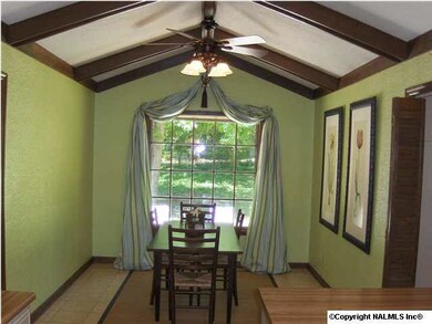 Oversized breakfast area in kitchen with vaulted ceiling, beams and beautiful view of the back yard.