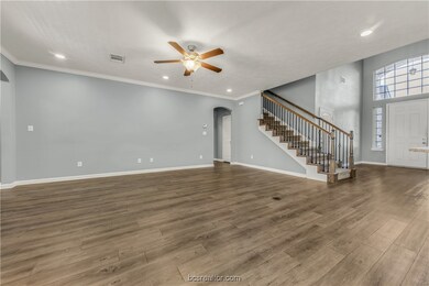 Unfurnished living room featuring hardwood / wood-style flooring, crown molding, and ceiling fan