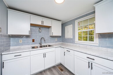 Kitchen with light stone countertops, sink, white