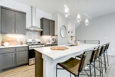 Modern chef’s kitchen featuring quartz counters, large island with seating, and abundant cabinetry.