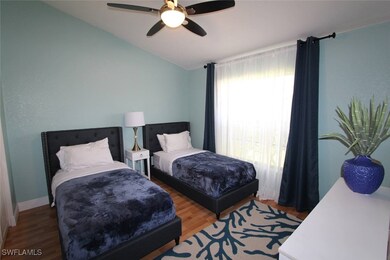 Bedroom featuring lofted ceiling, wood finished fl