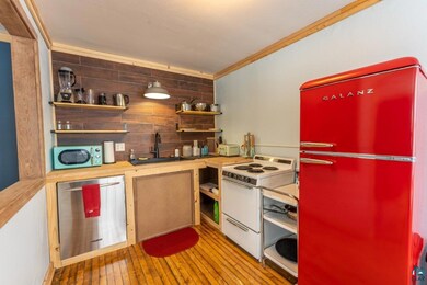 Kitchen with wooden counters, backsplash, white ap
