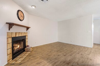 Unfurnished living room with a tile fireplace, lig