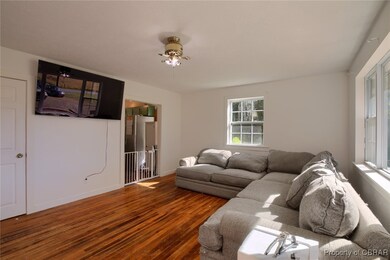 Living room featuring ceiling fan and hardwood / w