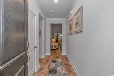 Hallway featuring crown molding, baseboards, and l