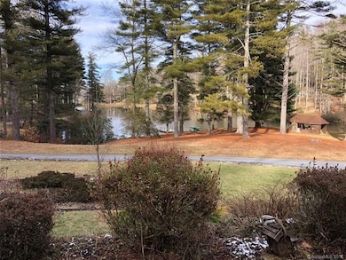The view from the front porch down to the community dock, boats, swimming area, and picnic shelter.