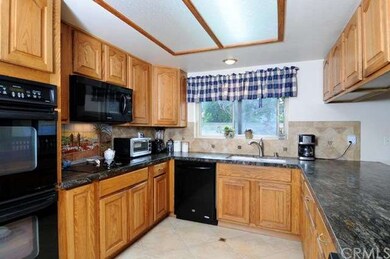Kitchen with custom granite opens directly to fami