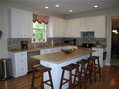 LIGHT AND BRIGHT KITCHEN, CENTER ISLAND IS GREAT FOR EXTRA SEATING OR JUST TO SIT AND TALK WITH THE COOK. 