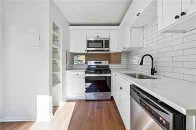 Kitchen with wood finished floors, a sink, white c