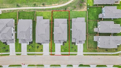 An aerial view of a spacious subdivision lake lot,